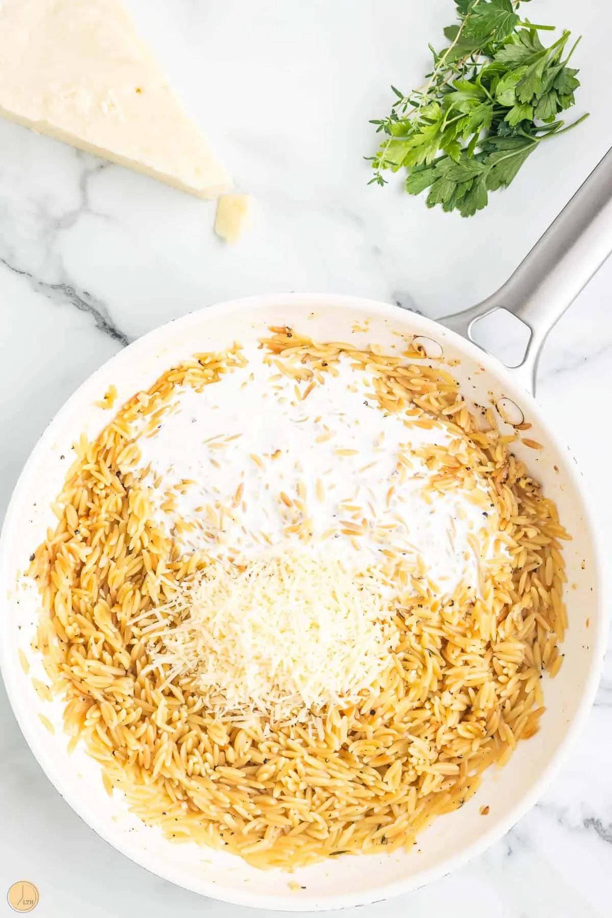 grated cheese and noodles in a pan