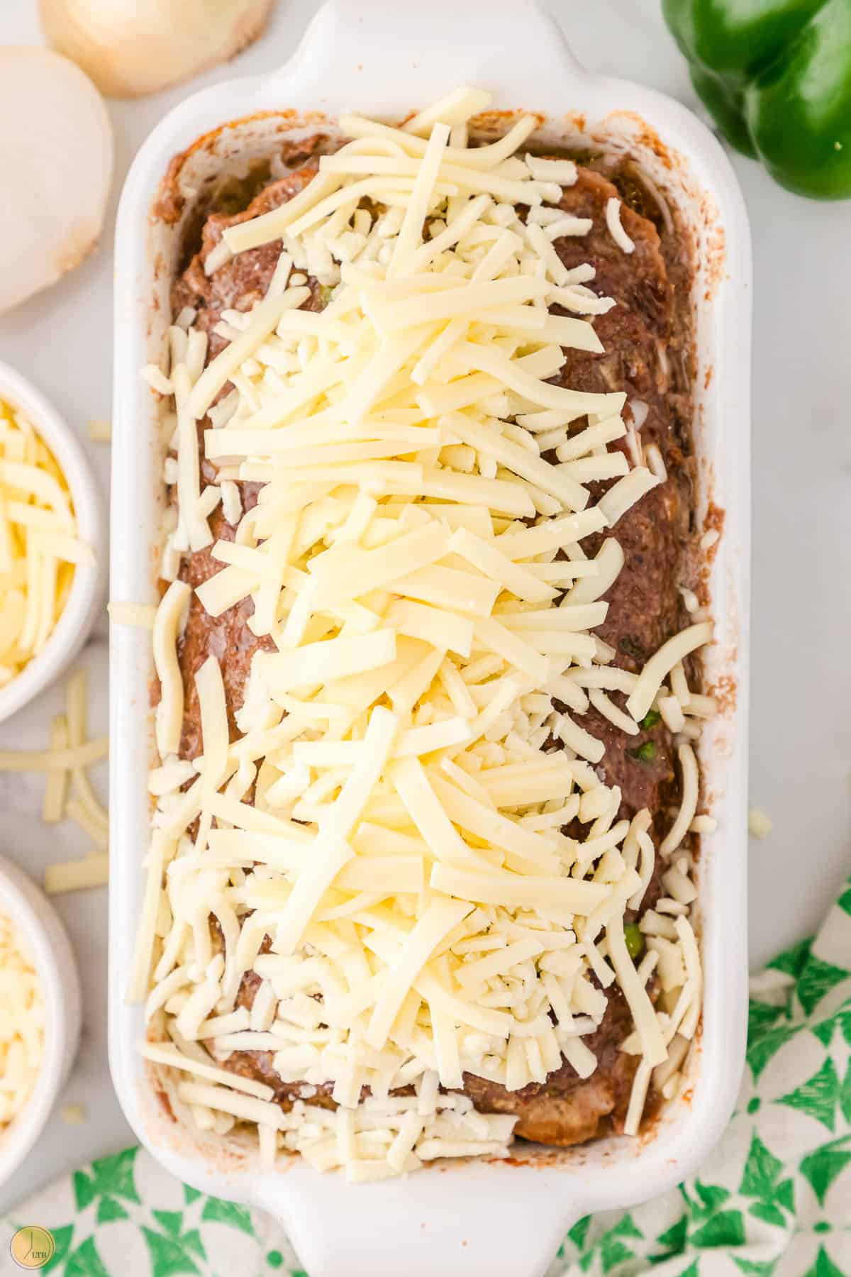 shredded cheese on a baked meatloaf