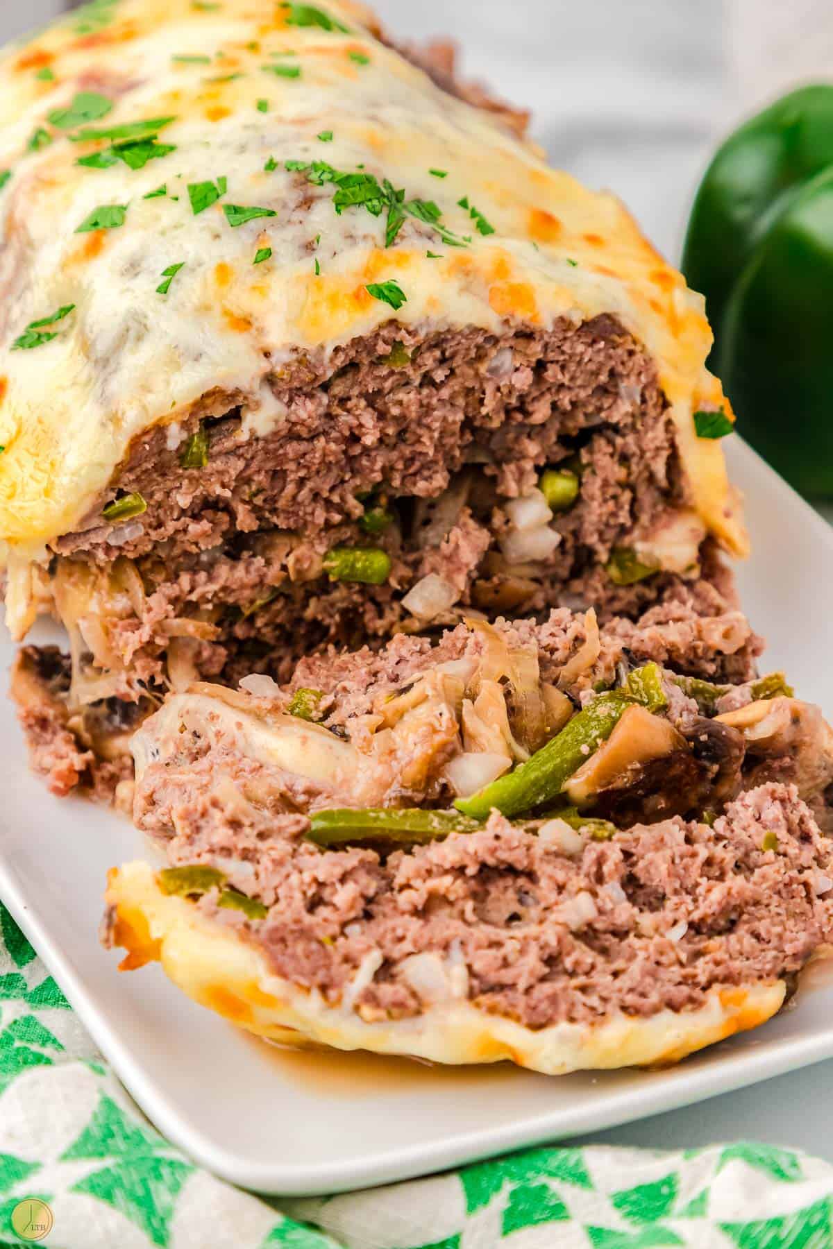 slices of philly cheesesteak meatloaf on a platter