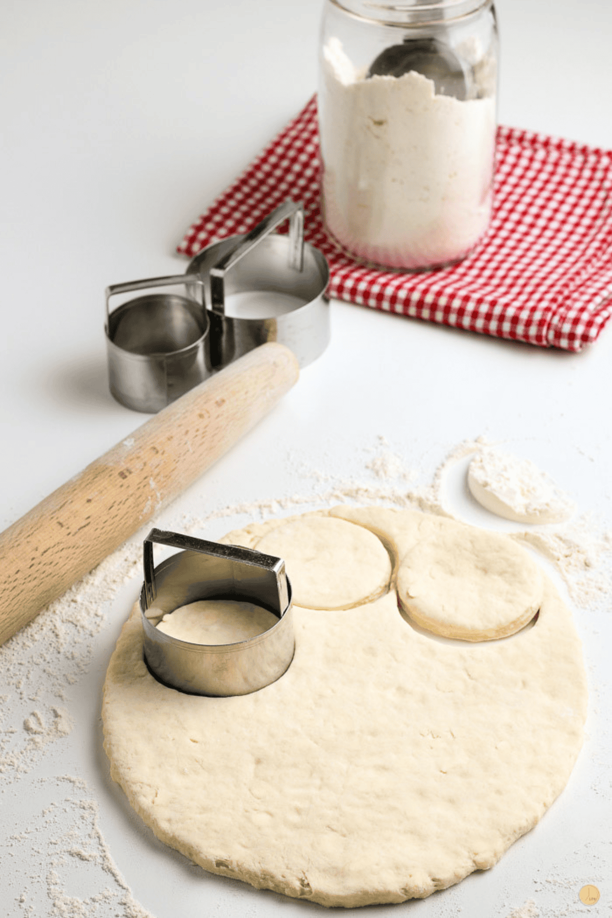 biscuit cutter cutting 3 biscuits out of dough