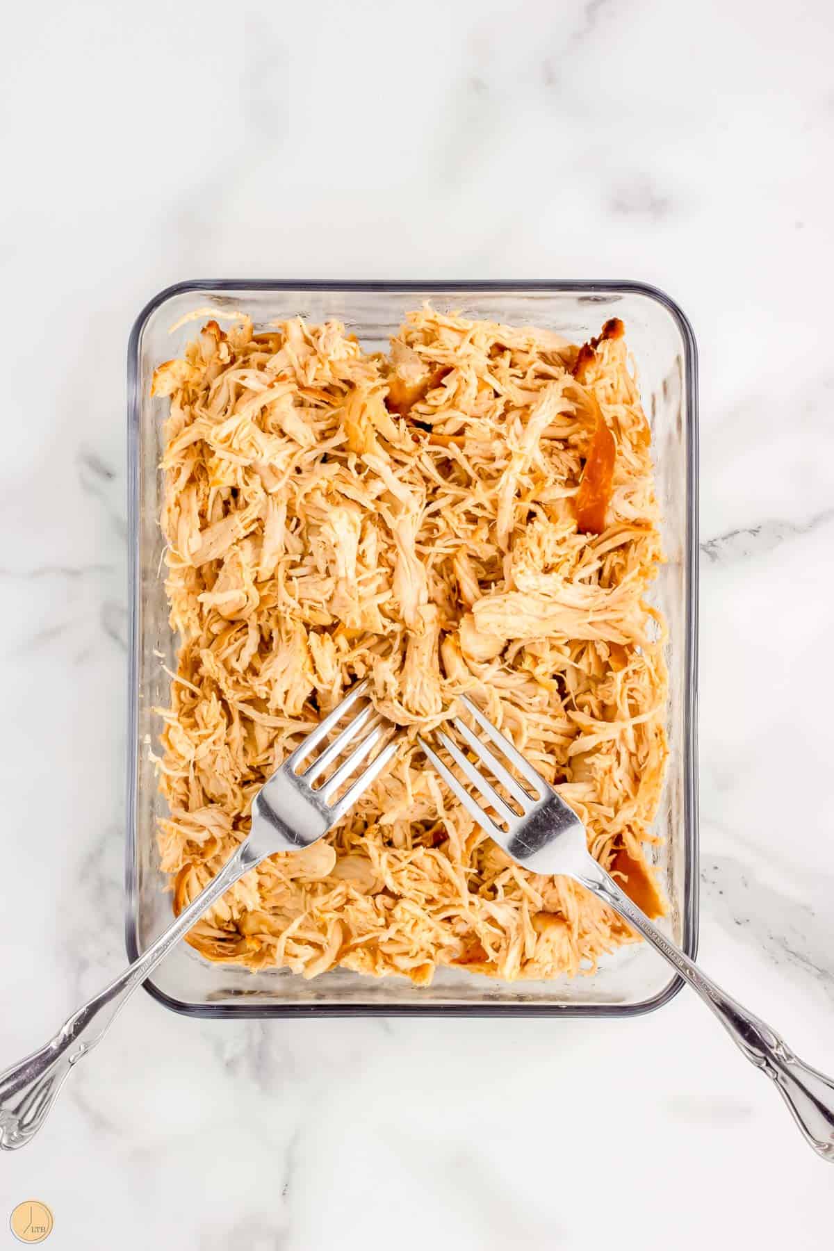 shredded chicken in a bowl with two forks