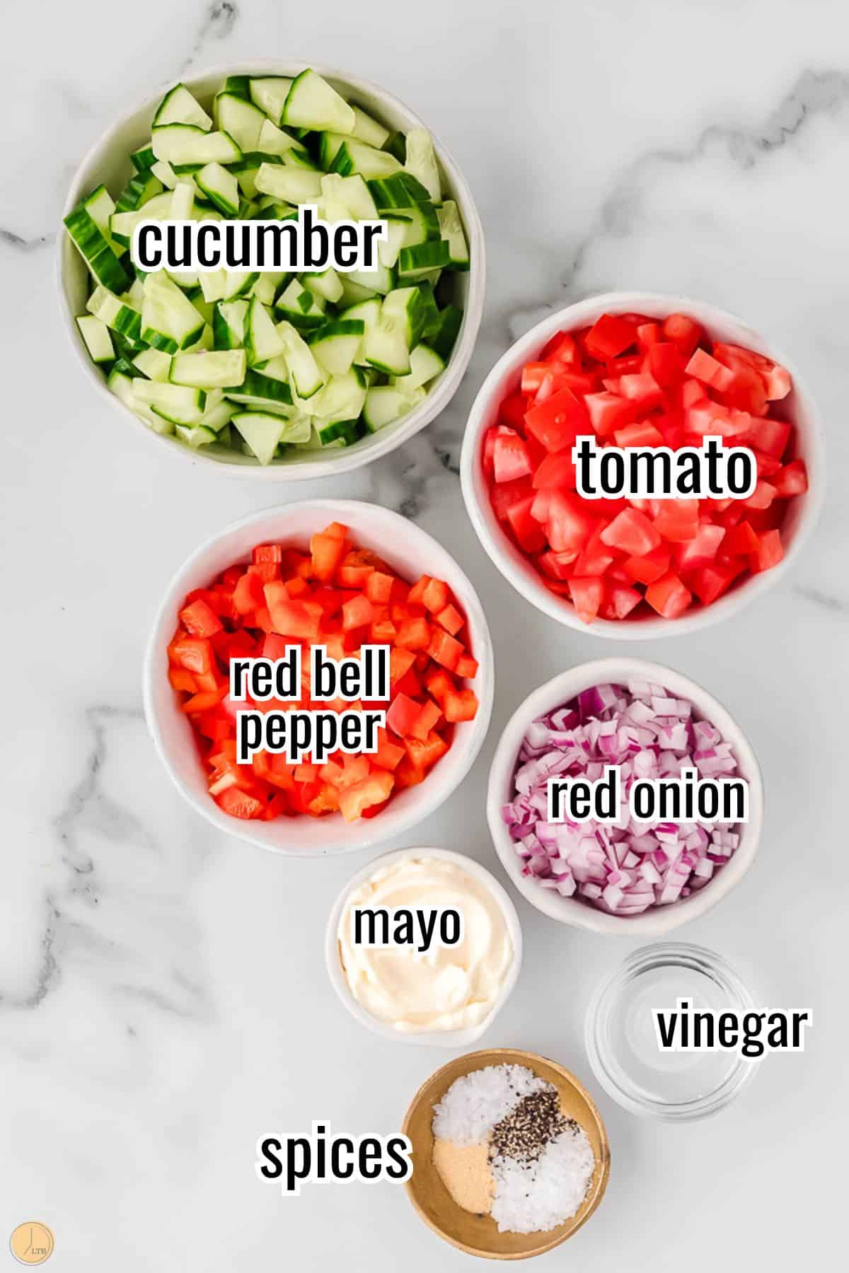 ingredients for a tomato salad recipe, including grape tomatoes, and dressing ingredients in a small bowl