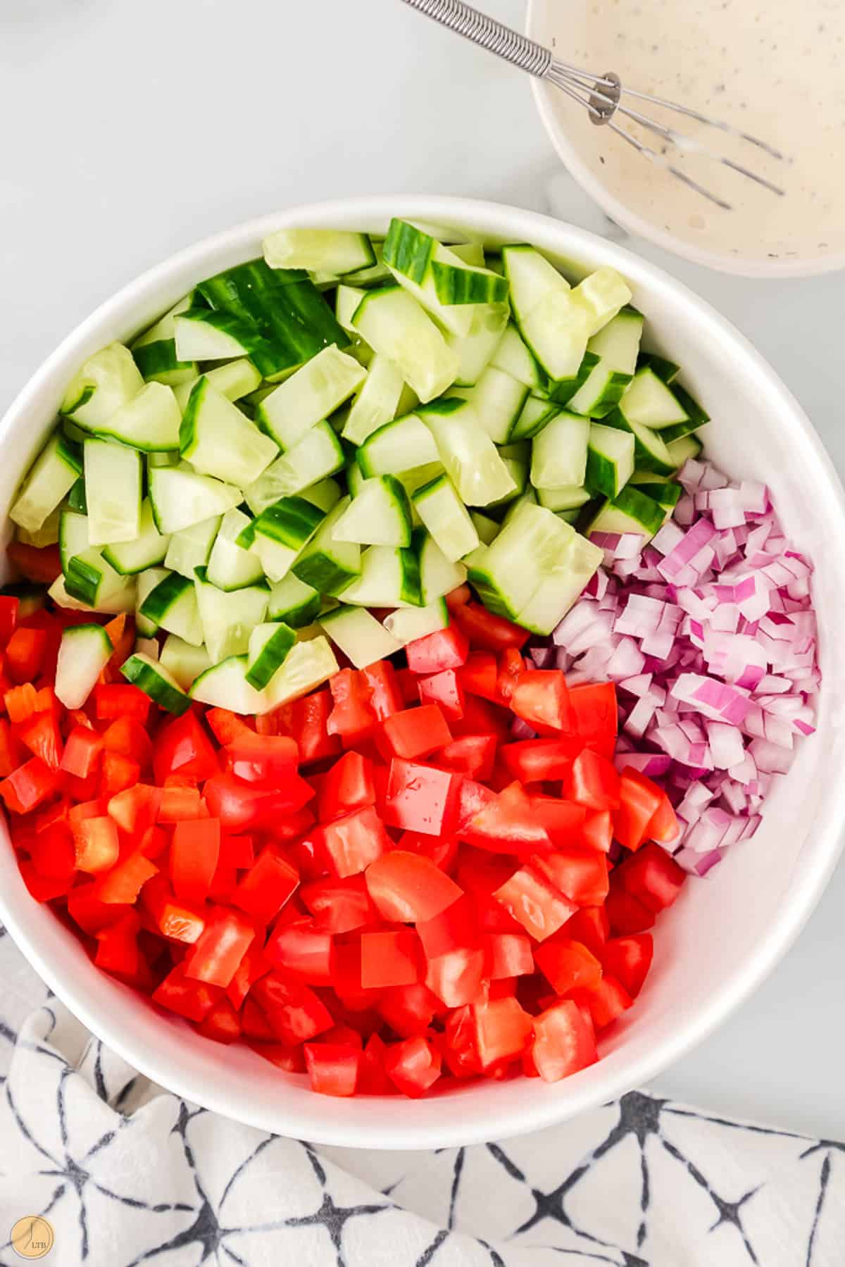 sliced cucumbers and diced tomatoes in a bowl