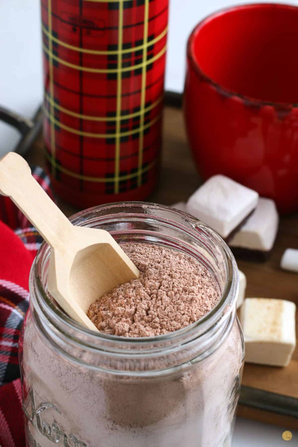 jar of hot chocolate mix with wooden spoon