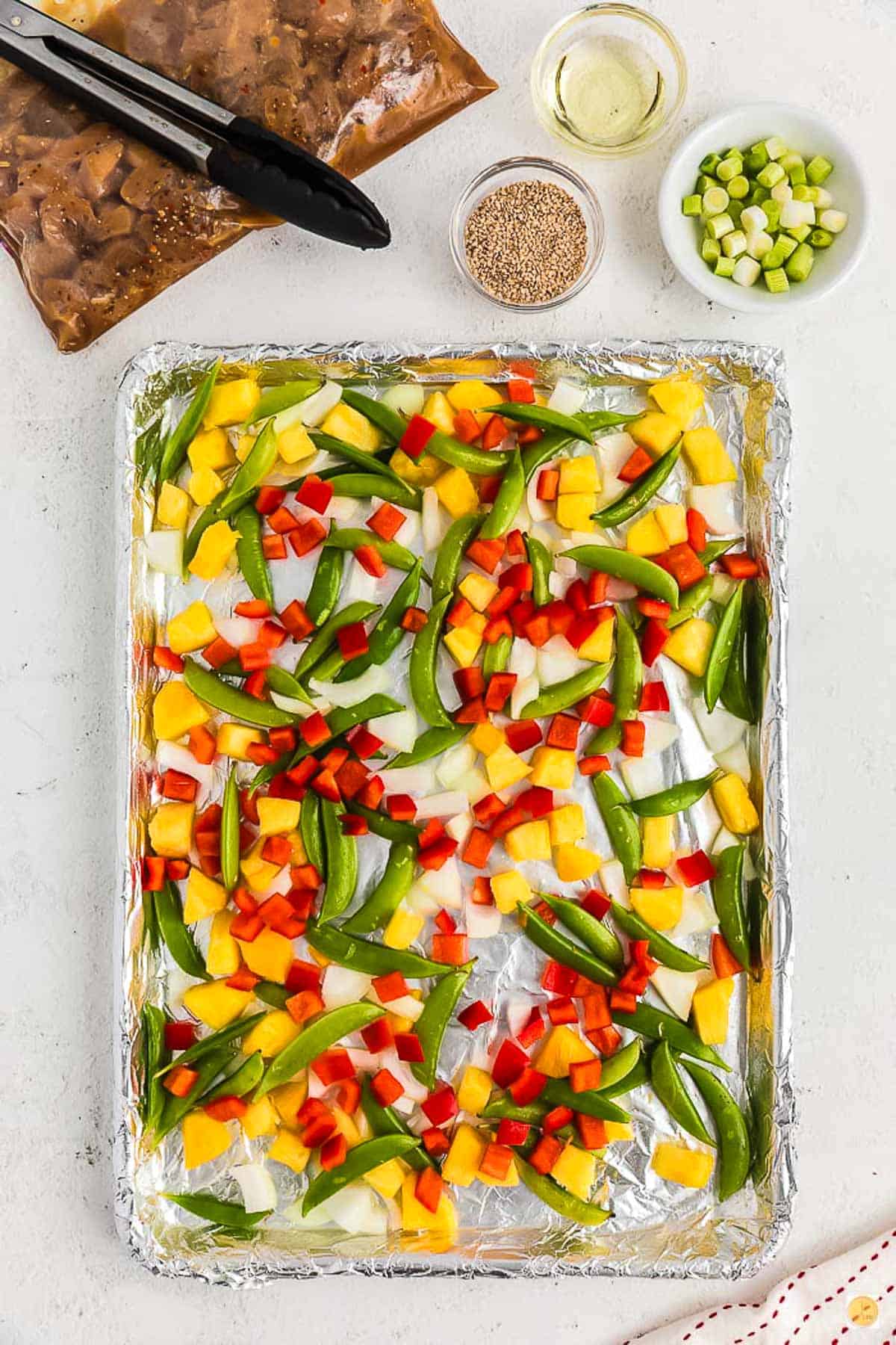 pan covered in foil topped with diced veggies