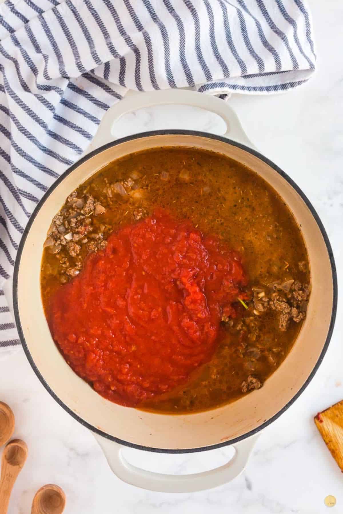 sauce with tomatoes and broth in a pot