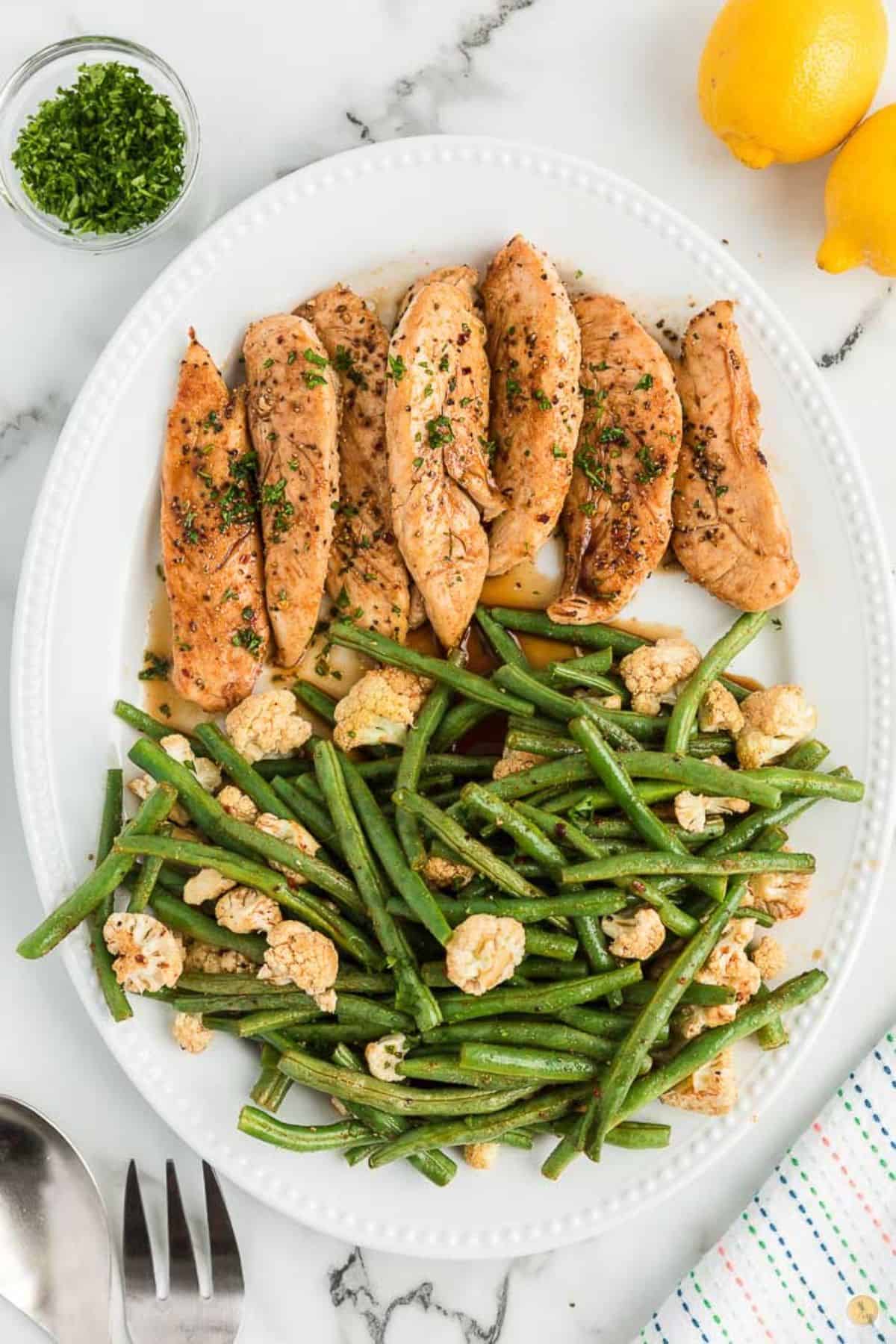 chicken and green beans on a white platter