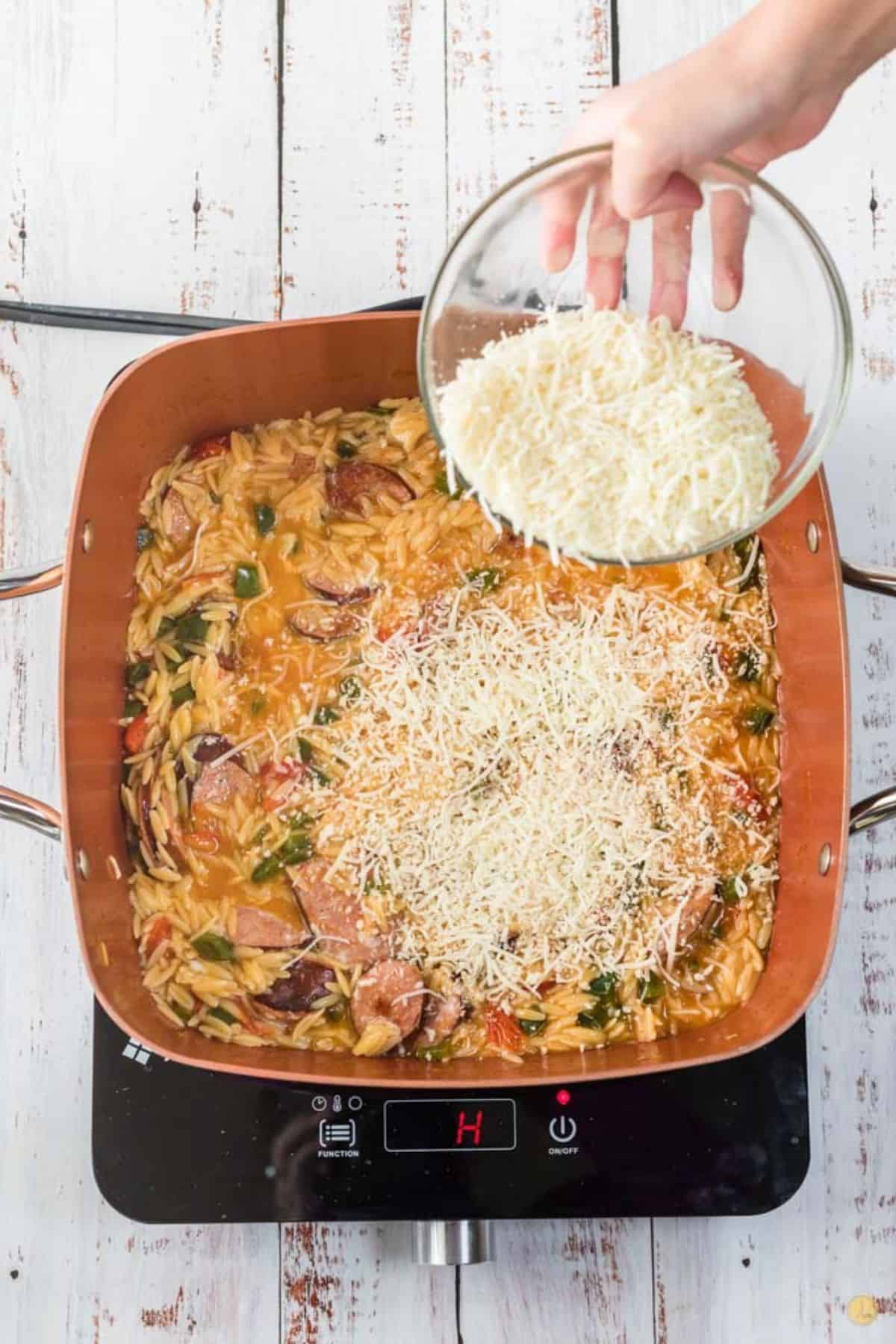 cheese being sprinkled onto a skillet meal