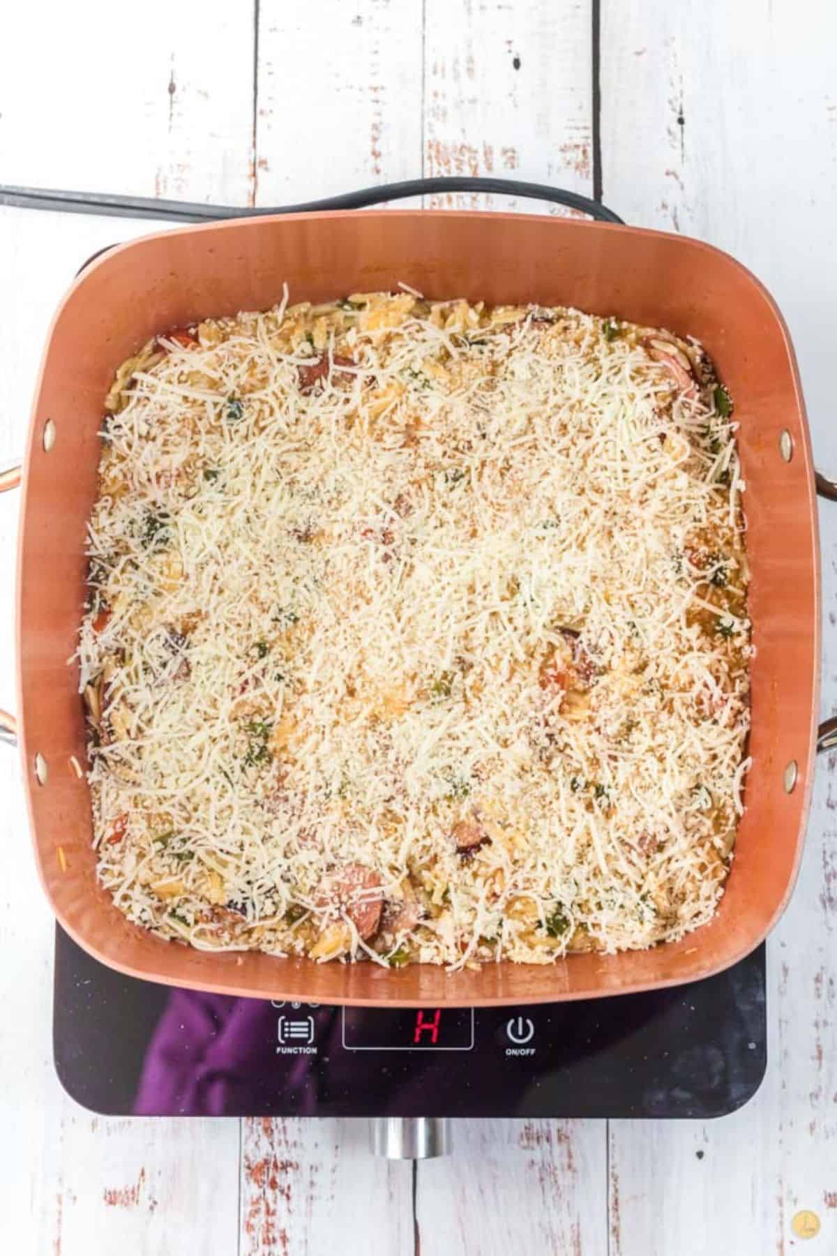 cheese sprinkled on a casserole in a skillet