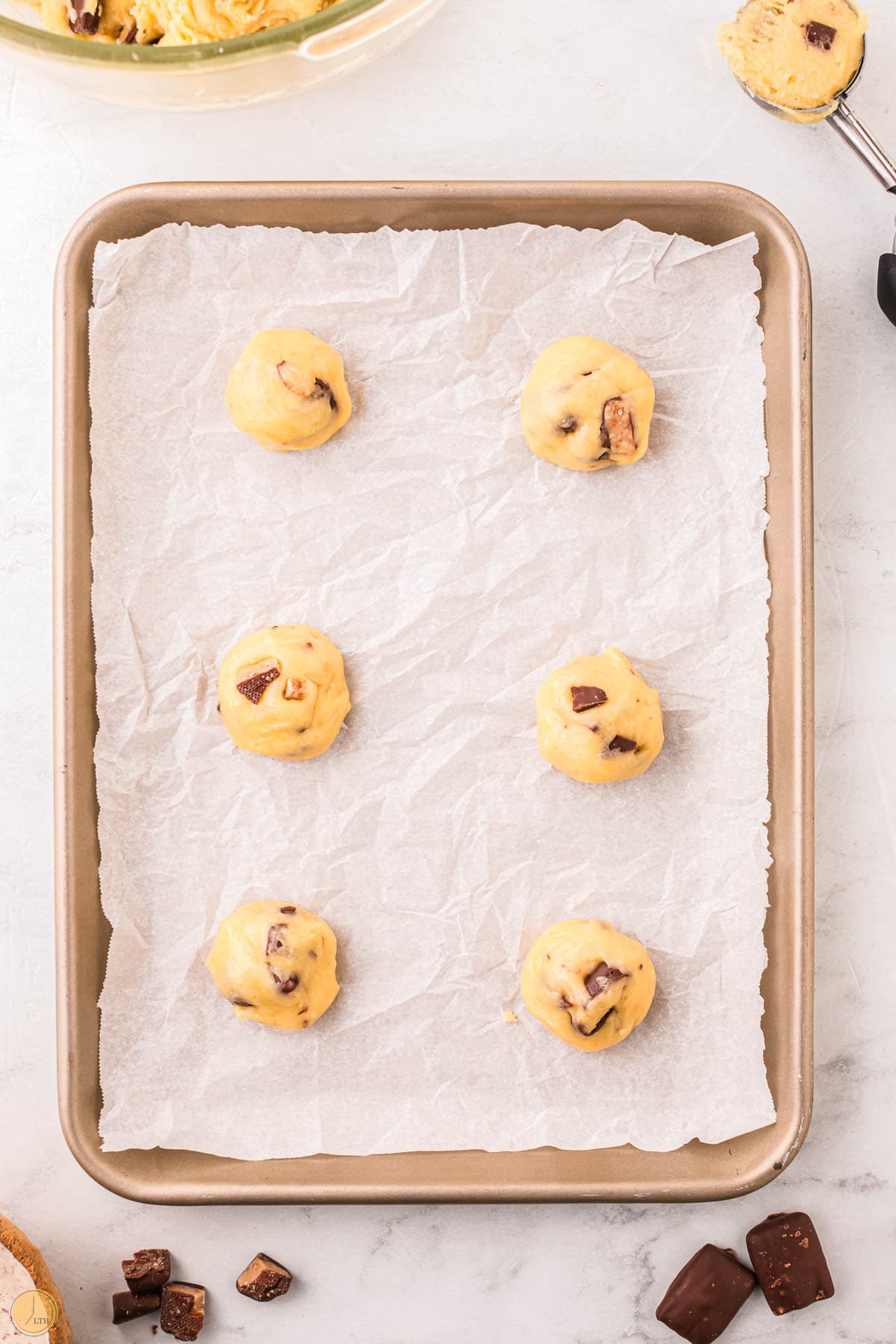 balls of cookie dough on a baking sheet