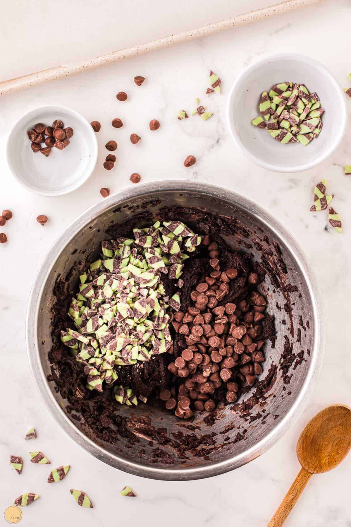 cookie dough with chocolate chips and mint chips in a metal bowl