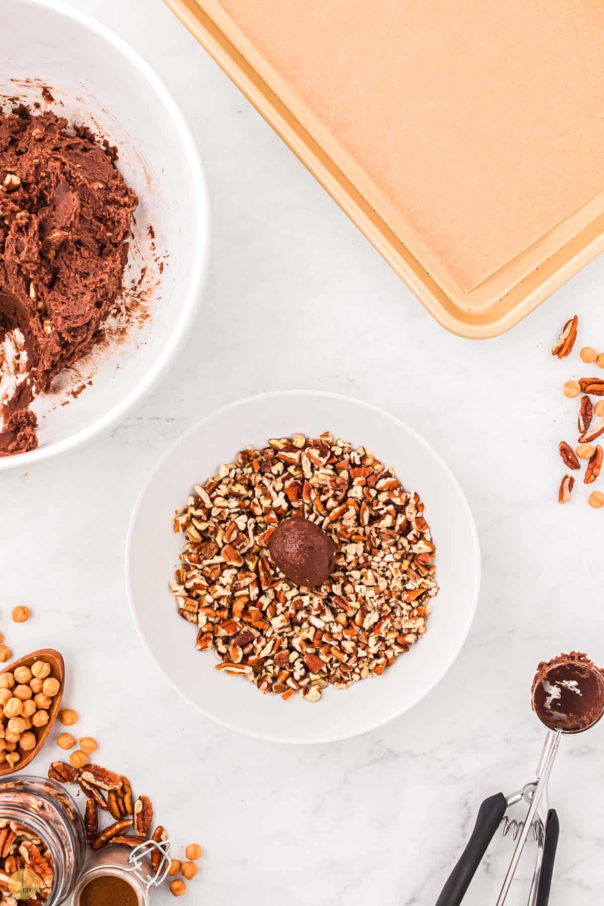 ball of cookie dough in a bowl of chopped pecans