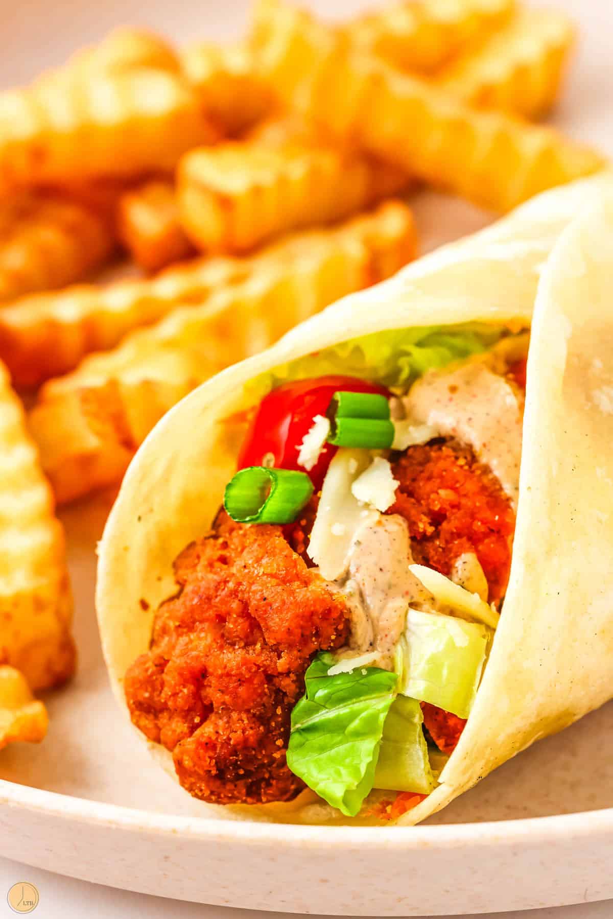 buffalo chicken wraps on a plate with french fries