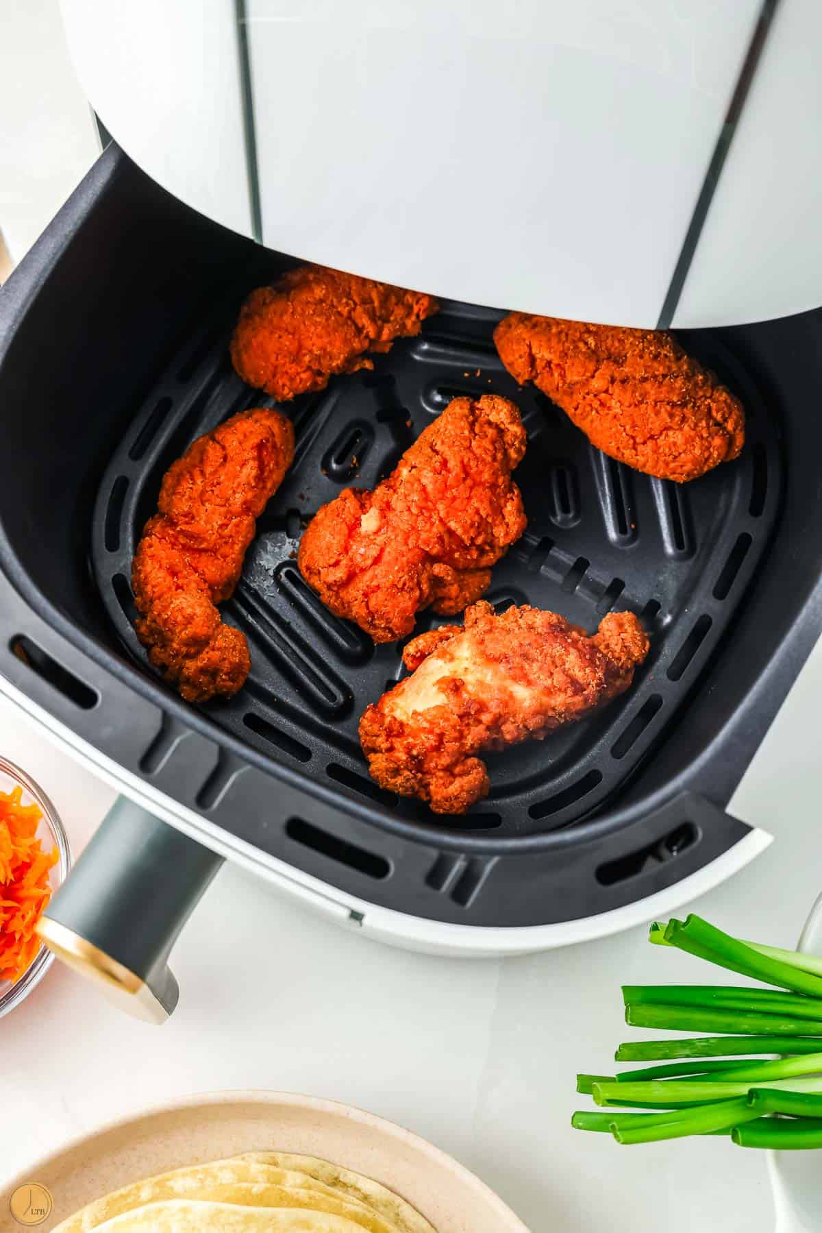 spicy chicken tenders in an air fryer basket