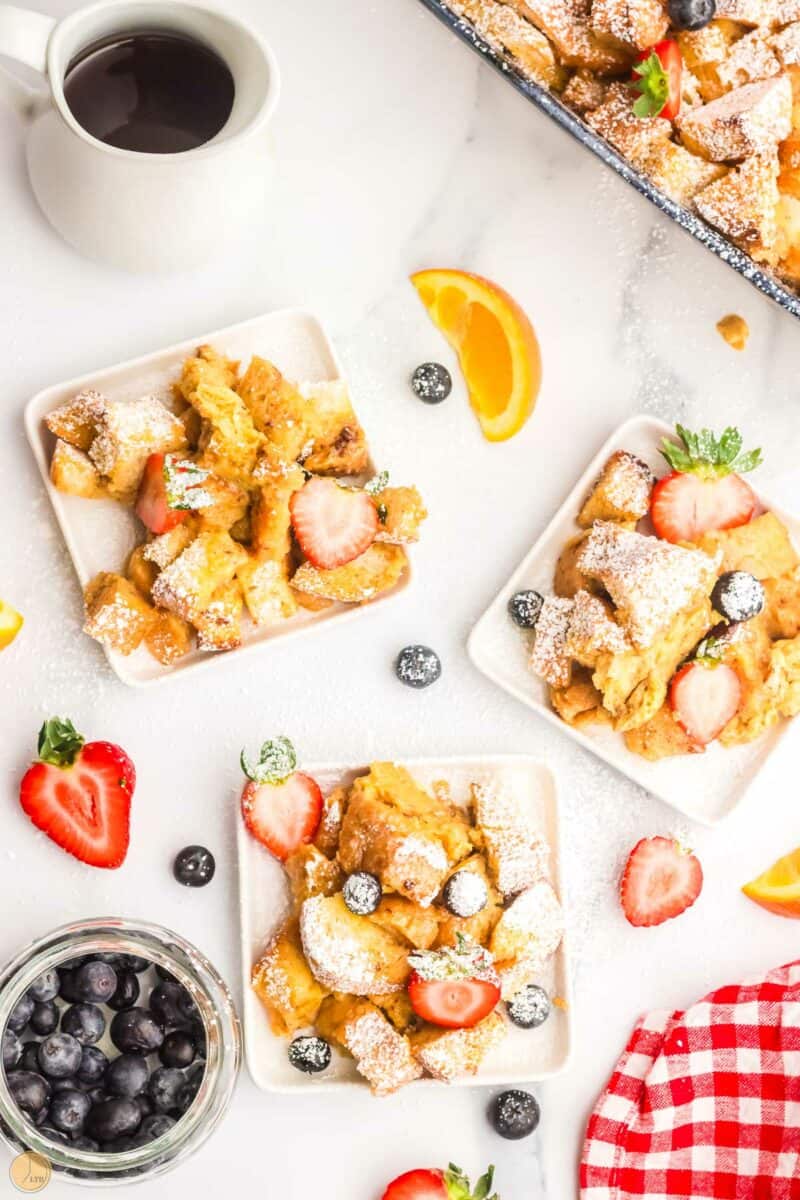 plates of french toast with bowls of fruit