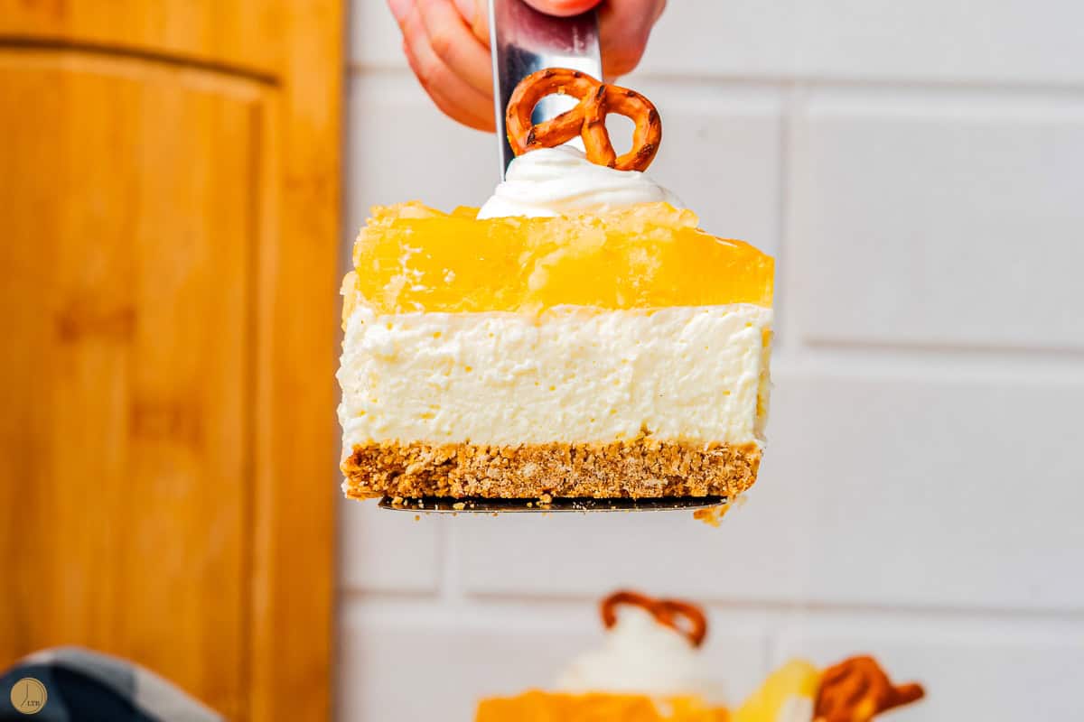 hand holding slice of pineapple pretzel salad