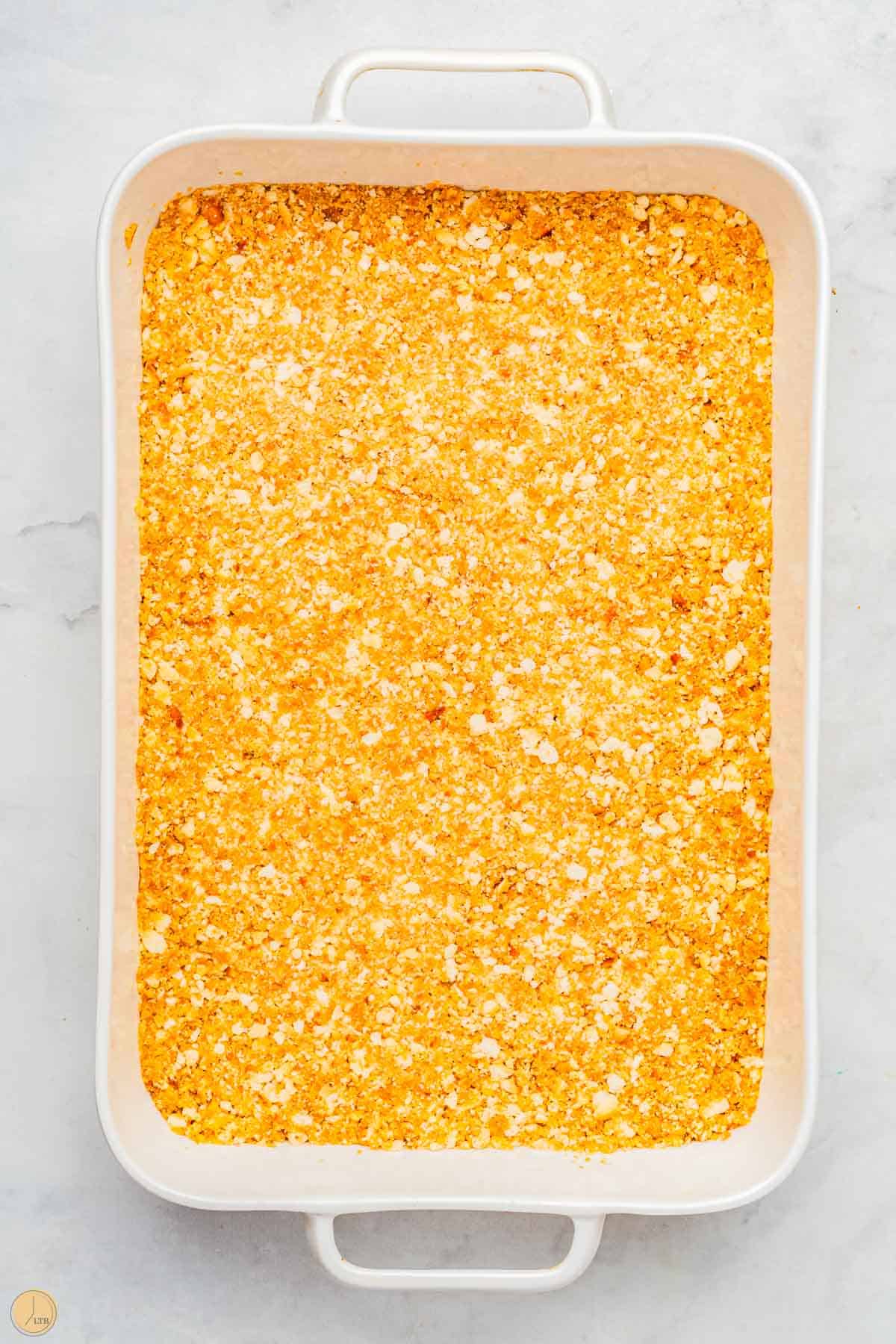pretzel crust in the bottom of a white baking dish