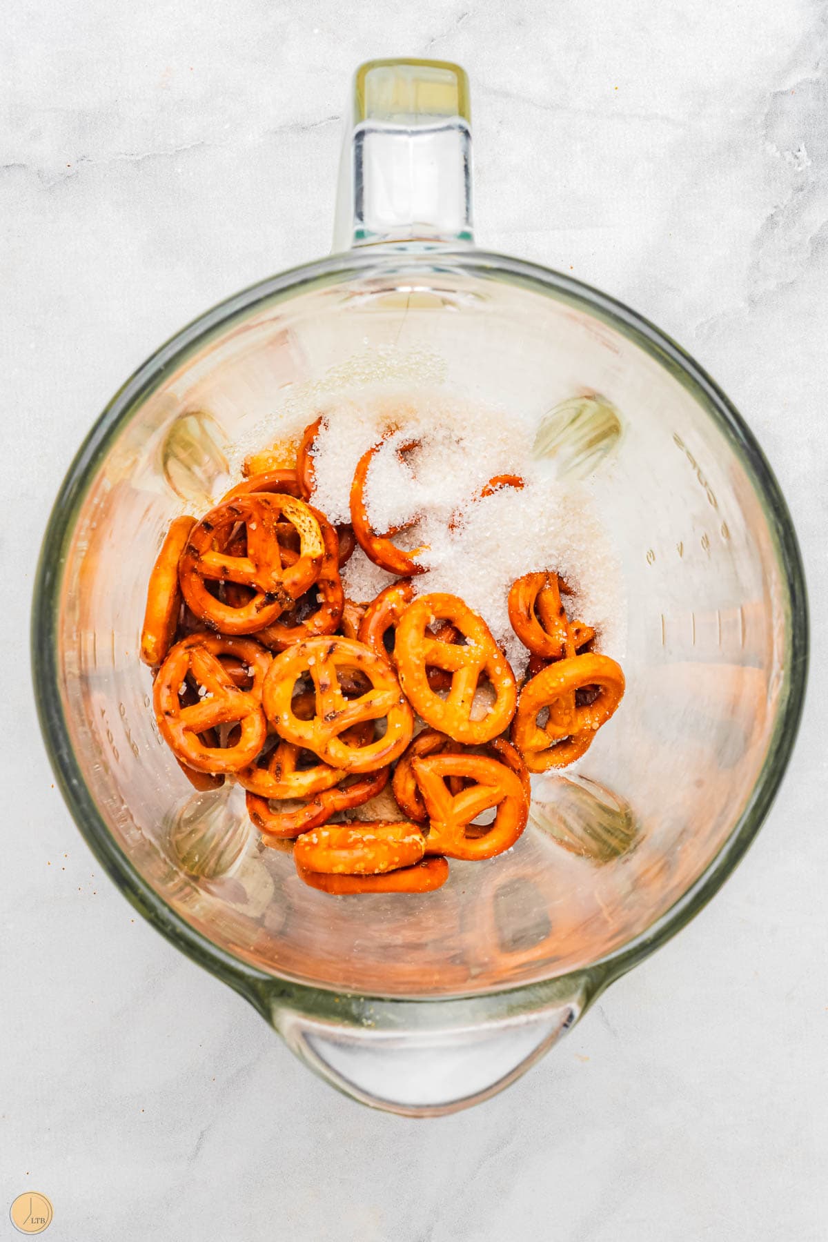 pretzels and sugar in a clear mixing bowl