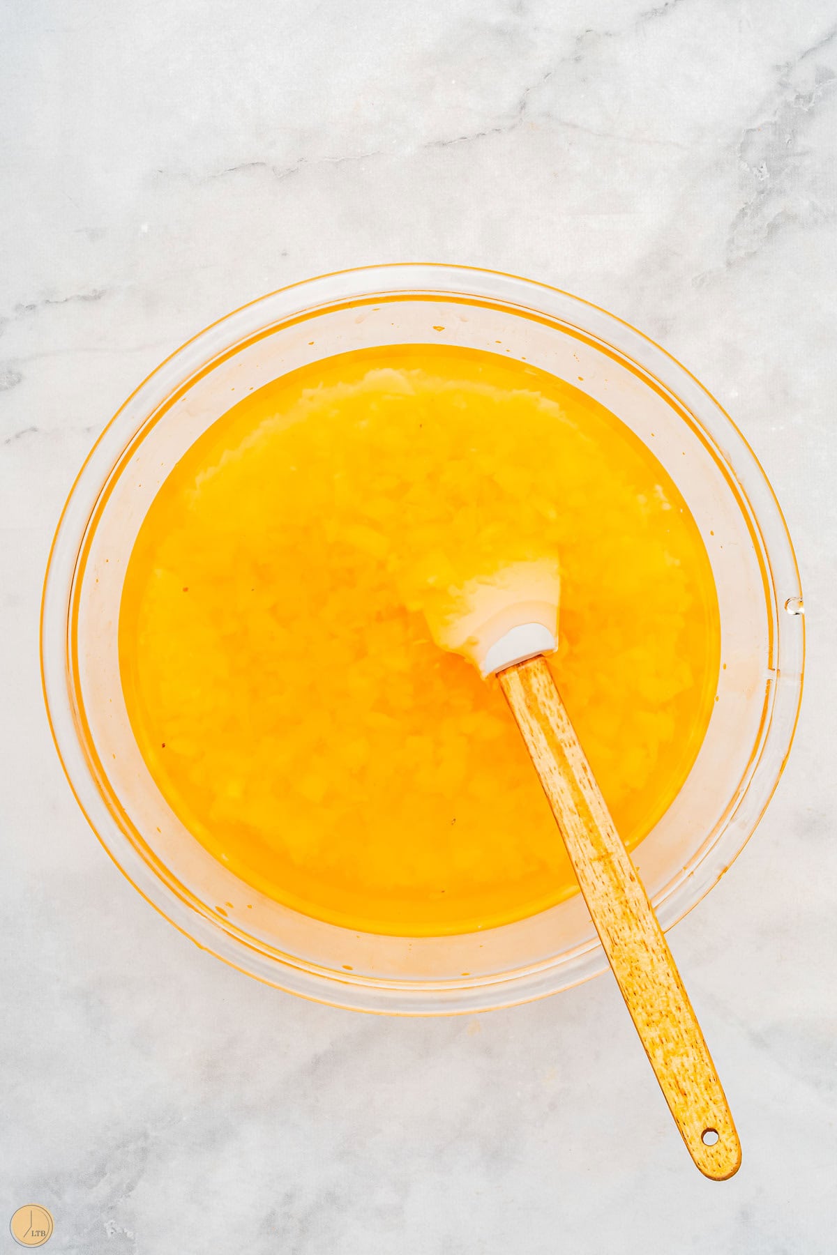 pineapple jello with crushed pineapple and a white spatula